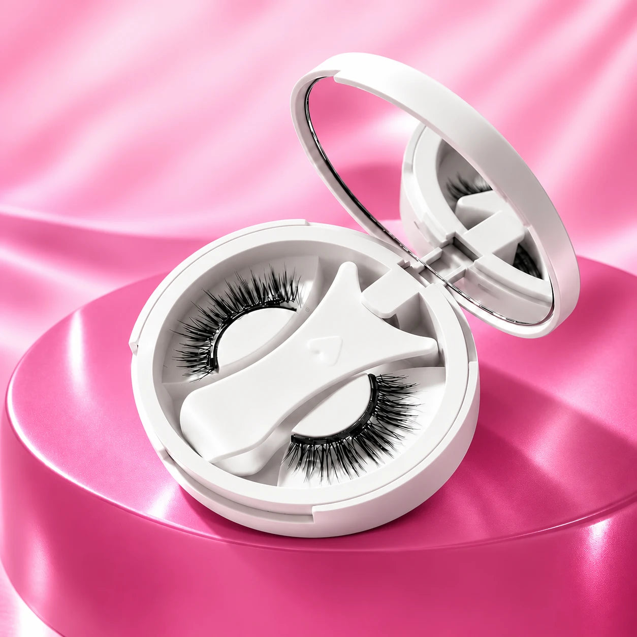 One open white magnetic lash compact containing the fitted white applicator and lash strips on a pink studio background. Reference-based illustration.